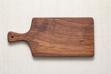 Walnut handmade wood cutting board on the linen. wooden cutting board.