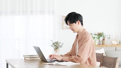 自宅でノートパソコンを使う男性	