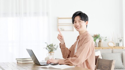 パソコンを使いながら指差しをする男性