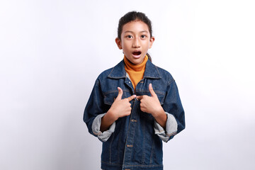 portrait of nervous, surprised and silly young little girl, pointing at herself anxiously looking with opened mouth at camera, being worried as picked for mission.