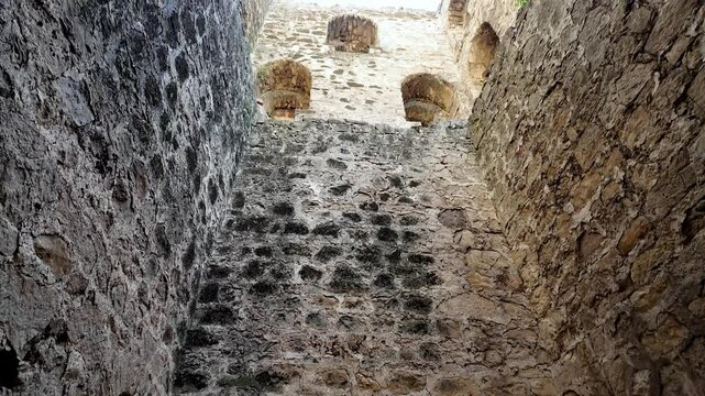 A view upwards from inside the Genoese Fortress in Feodosia, Crimea, Russia, showing the stone walls and arched openings.