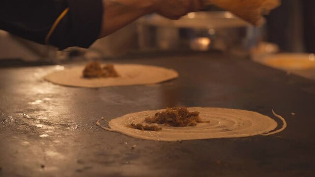 Indian food Dosa.indianlady making dosa with batter in Kitchen.very popular south Indian breakfast.