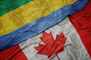 waving colorful flag of gabon and national flag of canada on the dollar money background. finance...
