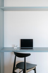 Obraz premium Personal laptop computer with empty display on blue desk at home office