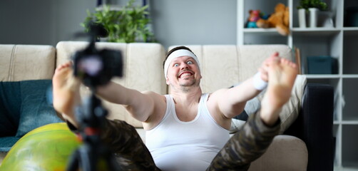 Vlogger freak shows his subscribers on camera how not to do the stretching correctly, holding his...