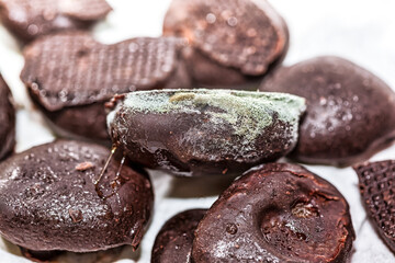 Bunch of chocolate covered in mold. Heap of chocolates has been overtaken by fungus.  Mold can produce toxins that may lead to food poisoning
