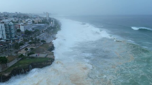 Drone flying over stormy sea in front of a city, real tropical cyclone footage
