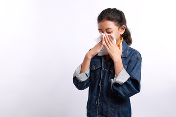 Sick little Asian girl wiping or cleaning nose with tissue isolated white background