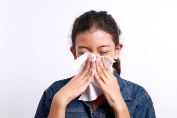Sick little Asian girl wiping or cleaning nose with tissue isolated white background