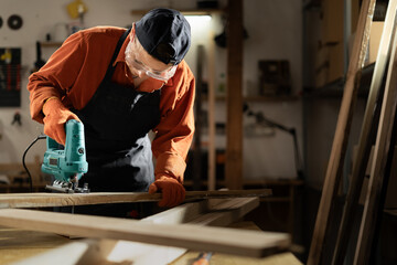 Skilled Female Carpenter Using Jigsaw in Workshop for Woodworking Project