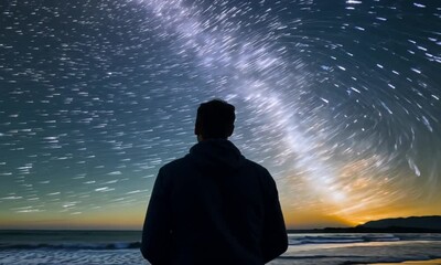 The man looks at the starry sky on the seashore