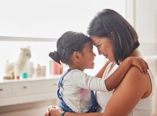 Happy, mom and kid with hug in home for support, affection and connection in childhood. Indonesian family, woman and little girl with embrace in living room for love, trust and care of daughter