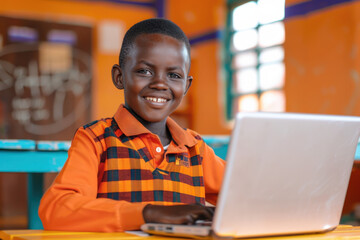 Portrait of a smiling african schoolboy using a laptop in a classroom, embracing technology for learning