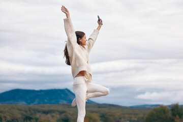 Fototapeta premium Mountain Adventure: Woman's Phone Call in the Beautiful Outdoors