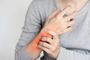 Person experiencing wrist pain, inflammation shown with red area on the wrist. Medical and health...