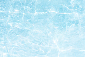 Blue water with ripples on the surface. Defocus blurred transparent blue colored clear calm water surface texture with splashes and bubbles. Water waves with shining pattern texture background.
