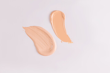 Two beautiful strokes of liquid foundation powder on a white background. Layout for design, texture...