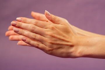 Beautiful female hand on isolated on purple background sign language applause a hand hitting...