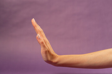 Beautiful female hand on isolated on purple background body language nude manicure hand showing...