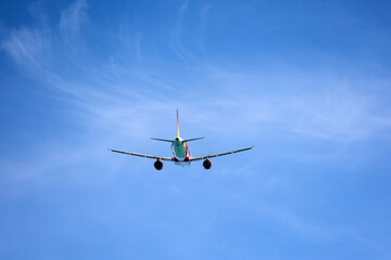 Airplane flying in blue sky, back view. Passenger plane at flight, travel concept