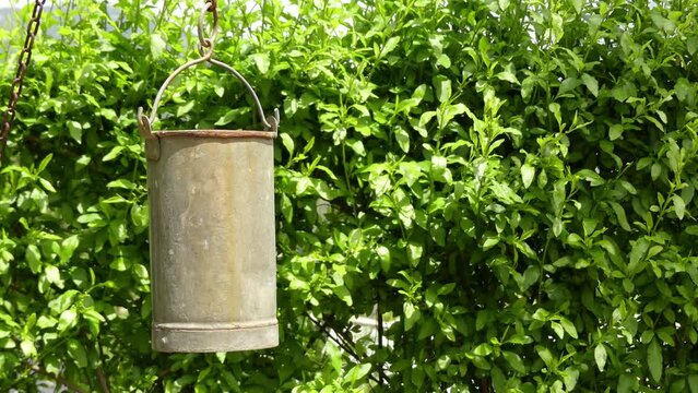 Cinemagraph loop: Metal bucket is swaying in wind