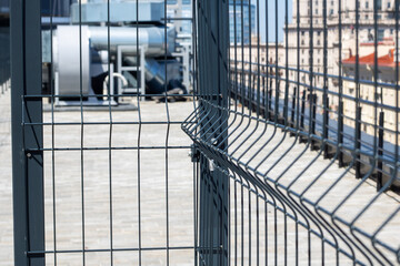 Obraz premium A close up of a metal fence with a building in the background on a city street