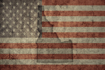 map of idaho state and flag of united states of america on a old vintage crack paper background .