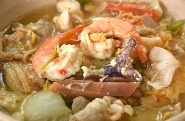 boiled sukiyaki seafood chicken and pork meat couple crispy pickled squid and shrimp with vegetable in soup on bowl dipping sauce