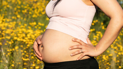 Pregnant woman showing piercing in her belly