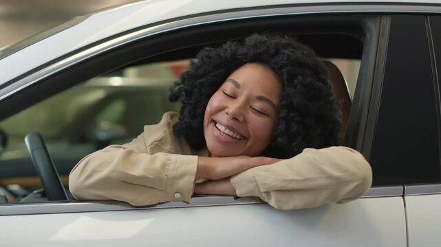 Happy smiling African American ethnic woman driver inside new car salon choosing auto in dealership joyful girl female buyer smile enjoy purchase buying luxury automobile rent buy vehicle bank credit