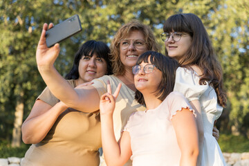 Family of women in a same-sex taking a sunset selfie outdoors