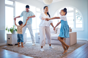 Happy family, dancing and playing with energetic children for bonding, weekend or holiday at home. Mother, father and kids enjoying music or fun activity with parents in living room together at house