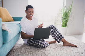 Photo of cheerful positive guy sleepwear pajama staying home sofa video call modern device indoors...
