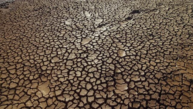 Gimbal shot of wet cracking ground across the savanna at evening in kenya