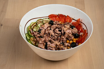 Top view of a fresh salad bowl with crispy chicken, cucumbers, tomatoes, and red onions