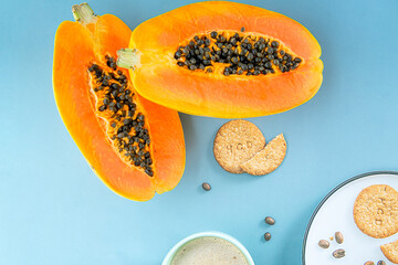 Papaya fruit on a blue background. Slices of sweet papaya on a blue background with cookies