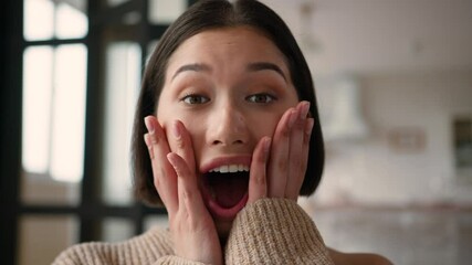 Portrait close up shocked Caucasian hispanic latin woman girl happy reaction shock emotion open mouth hold face excited female winner wonder amazing unexpected good news win surprise rejoice at home