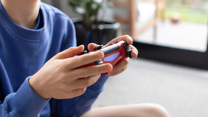 Close-up of a boy's hands holding a game controller. Video games, game consoles.