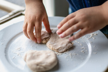 Child having fun modeling salt dough, authentic activity, fine motor skills development