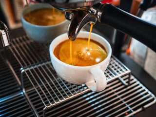 Close-up of espresso pouring from the coffee machine into a coffee cup. Professional coffee brewing