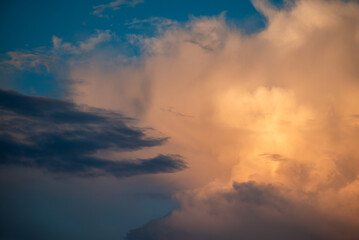 Warm sunshine on the white clouds. Beautiful evening sky, picturesque view on nature at sunset