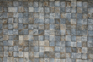 A wall made of gray and brown tiles