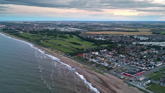 Aerial perspective: Skegness coastal town captured by drone at summer sunset. Video displays holiday park, sea, beach, caravans