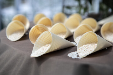 Wooden cones filled with rice resting on a table before a wedding ceremony