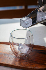glass with ice cubes on the table