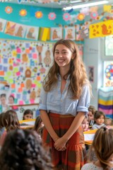Young female teacher smiling at students in colorful classroom