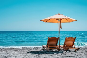 Two wooden chairs are set under an orange umbrella on a serene sandy beach with crystal blue waters and a clear sky in the background, creating a relaxing scene.