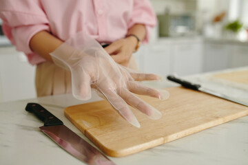 Close-up of housewife wearing gloves to cook dish in the kitchen