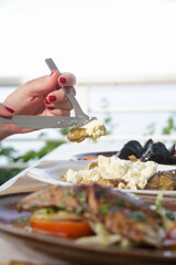Woman having healthy meal in the restaurant, close up image of fork and plate
