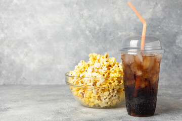 Tasty popcorn in buckets and cold cola drinks with cinema tickets, movie clapper and 3D eyeglasses...